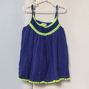 A tank top with puff balls at the end